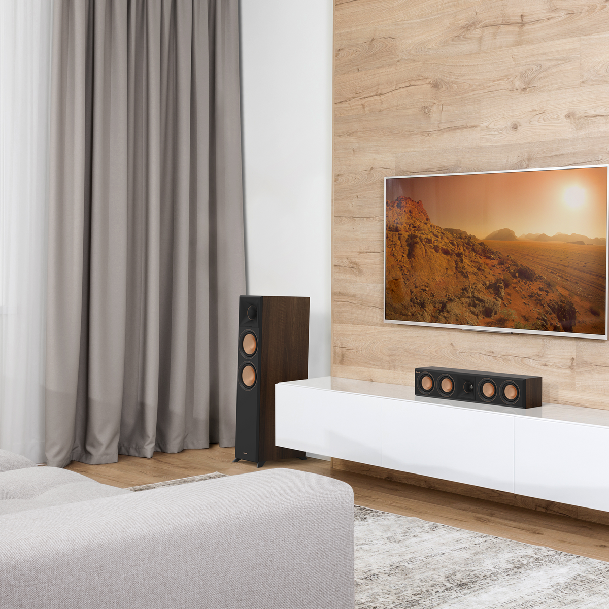 Klipsch RP-404C II Ebony RP 404C II sitting on a white credenza under a TV with its grille off